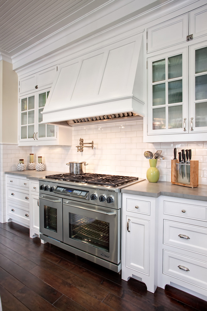 Inspiration for a large traditional u-shaped eat-in kitchen in San Diego with a farmhouse sink, beaded inset cabinets, white cabinets, marble benchtops, white splashback, subway tile splashback, stainless steel appliances, dark hardwood floors and with island.