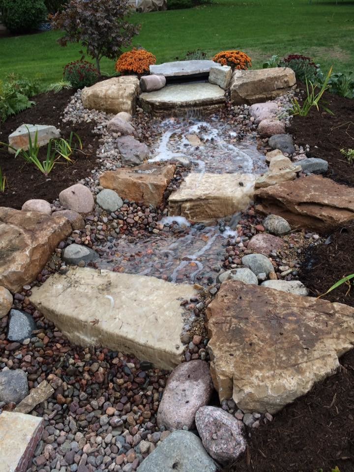 Design ideas for a mid-sized transitional full sun gravel water fountain landscape in Chicago for summer.