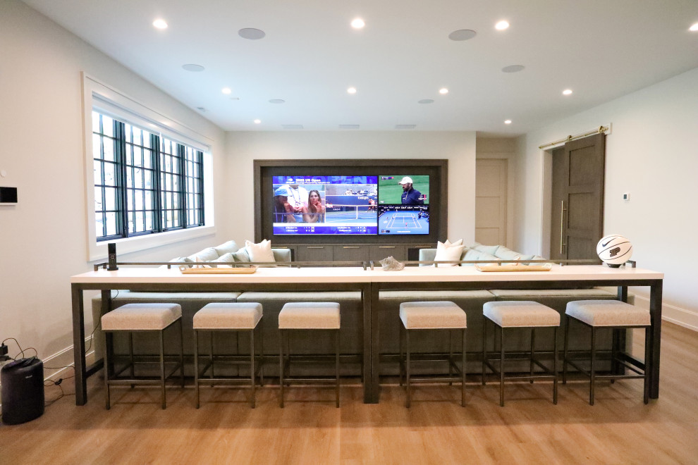 Large open concept light wood floor home theater photo in Other with white walls and a media wall