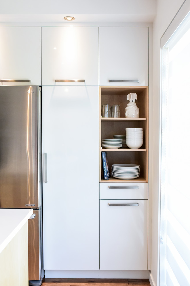 Inspiration for a small scandinavian l-shaped separate kitchen in Montreal with an undermount sink, flat-panel cabinets, white cabinets, quartzite benchtops, white splashback, ceramic splashback, stainless steel appliances, medium hardwood floors, with island and orange floor.