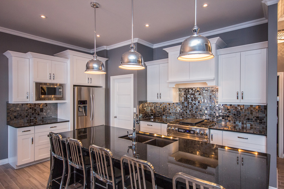 This is an example of a mid-sized transitional l-shaped eat-in kitchen in Calgary with a double-bowl sink, shaker cabinets, white cabinets, multi-coloured splashback, mosaic tile splashback, stainless steel appliances, porcelain floors, with island and quartz benchtops.