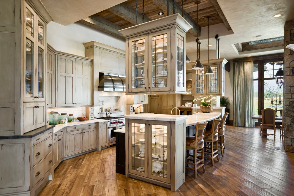 Design ideas for a country eat-in kitchen in Other with glass-front cabinets, beige cabinets, beige splashback and stainless steel appliances.