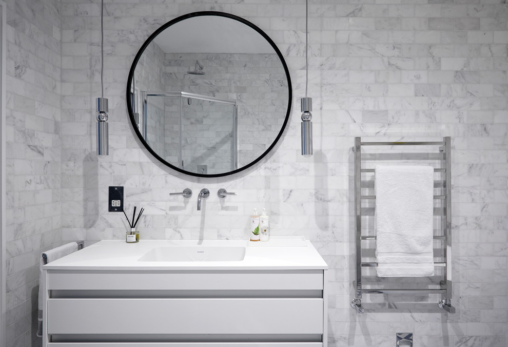 This is an example of a mid-sized contemporary master bathroom in London with flat-panel cabinets, white cabinets, a freestanding tub, a corner shower, a one-piece toilet, gray tile, porcelain tile, ceramic floors, a drop-in sink, granite benchtops, blue floor and a hinged shower door.