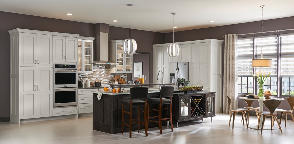 Large transitional l-shaped eat-in kitchen photo with shaker cabinets, white cabinets and an island