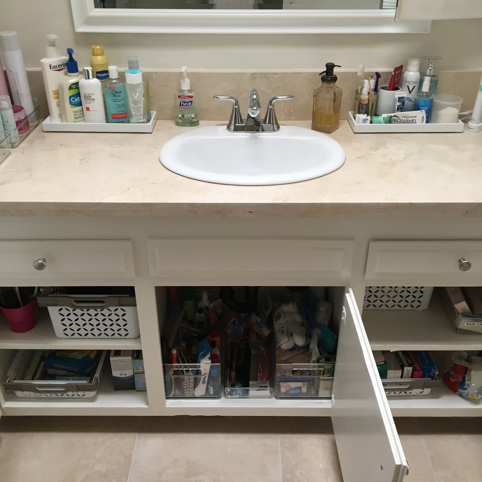 Photo of a small contemporary bathroom in Los Angeles with raised-panel cabinets, white cabinets and solid surface benchtops.