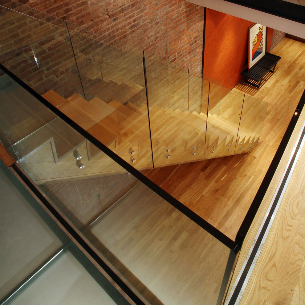 Design ideas for a contemporary wood straight staircase in New York with wood risers and glass railing.