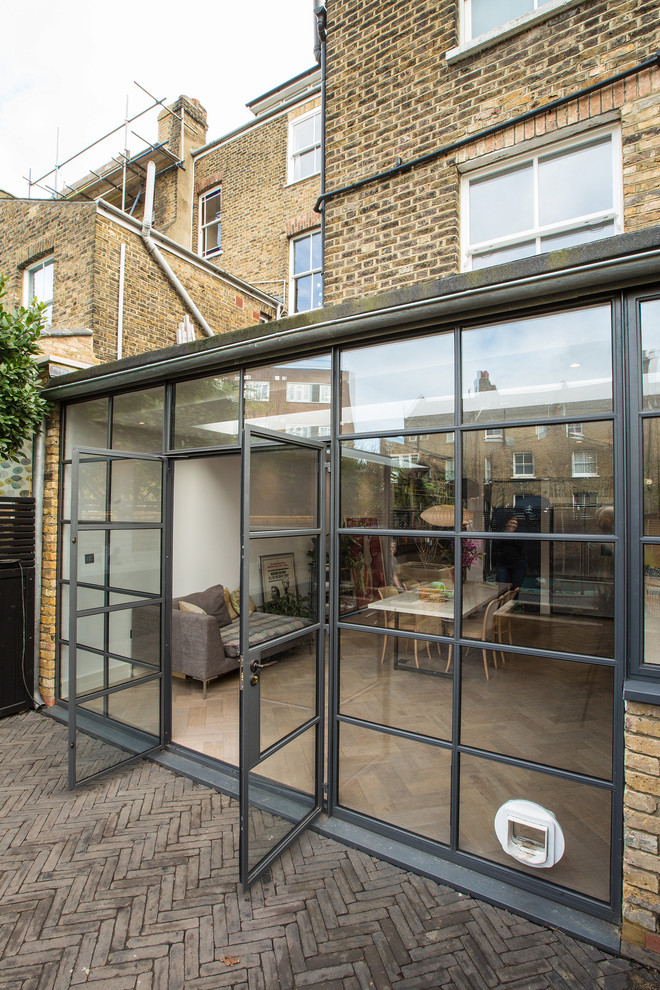 Large contemporary brick townhouse exterior in London with a flat roof and a mixed roof.