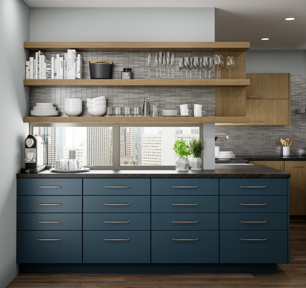 Inspiration for a large contemporary l-shaped open plan kitchen in Los Angeles with a farmhouse sink, flat-panel cabinets, blue cabinets, soapstone benchtops, grey splashback, mosaic tile splashback, stainless steel appliances, medium hardwood floors, with island, brown floor and black benchtop.