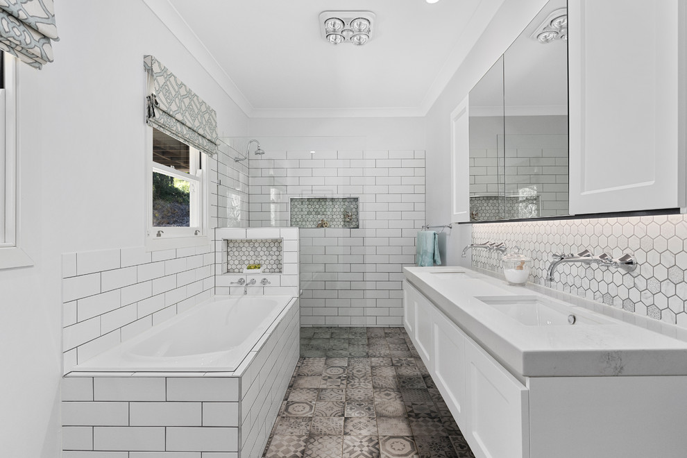 Inspiration for a transitional master bathroom in Brisbane with shaker cabinets, white cabinets, a drop-in tub, a curbless shower, white tile, subway tile, grey walls, an undermount sink, grey floor, an open shower and grey benchtops.
