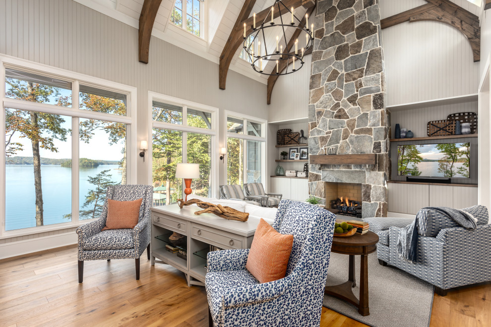 Inspiration for a transitional open concept living room in Other with grey walls, medium hardwood floors, a standard fireplace, a stone fireplace surround, a wall-mounted tv, brown floor, exposed beam, timber, vaulted and panelled walls.