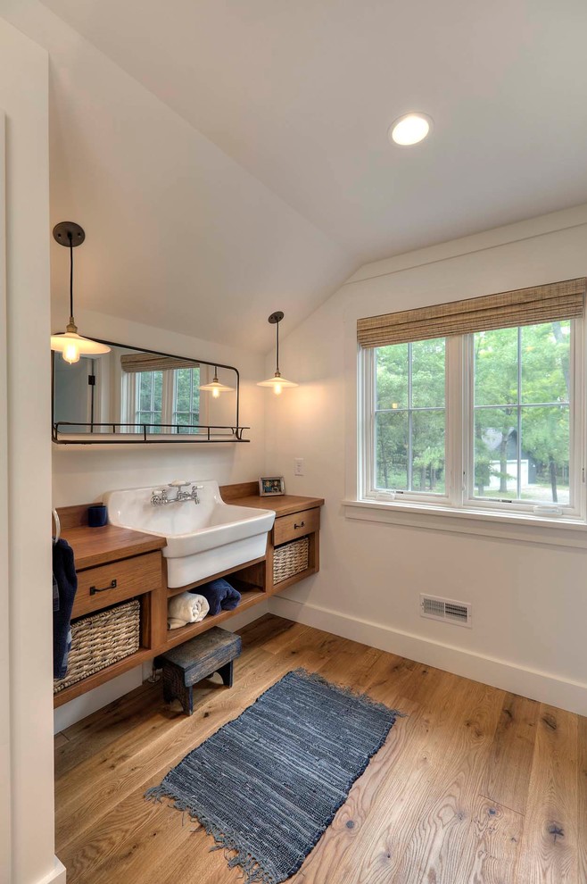 Photo of a large beach style bathroom in Other with a drop-in sink, flat-panel cabinets, medium wood cabinets, white walls, medium hardwood floors, wood benchtops and brown benchtops.