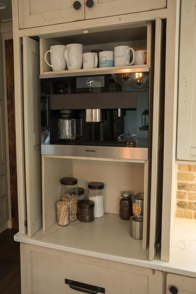 Example of a large transitional galley dark wood floor and brown floor open concept kitchen design with a farmhouse sink, shaker cabinets, quartz countertops, brown backsplash, brick backsplash, stainless steel appliances and an island