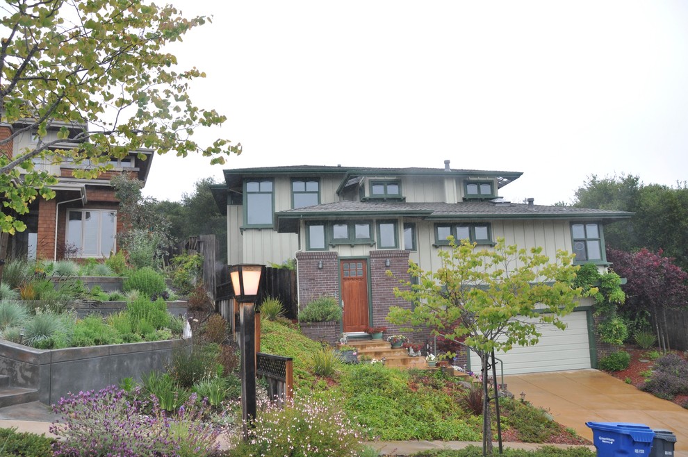 This is an example of a mid-sized arts and crafts two-storey brick green exterior in San Francisco with a hip roof.