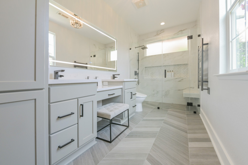 Inredning av ett modernt litet vit vitt badrum med dusch, med släta luckor, grå skåp, marmorbänkskiva, en kantlös dusch, dusch med gångjärnsdörr, en toalettstol med hel cisternkåpa, klinkergolv i keramik, ett undermonterad handfat och grått golv