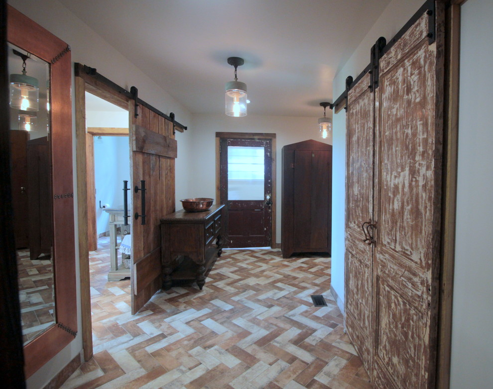 Photo of a mid-sized country gender-neutral dressing room in Atlanta with raised-panel cabinets, distressed cabinets, brick floors and multi-coloured floor.