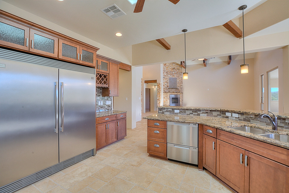Large country galley kitchen in Albuquerque with a double-bowl sink, shaker cabinets, medium wood cabinets, granite benchtops, brown splashback, glass tile splashback, stainless steel appliances, travertine floors and no island.