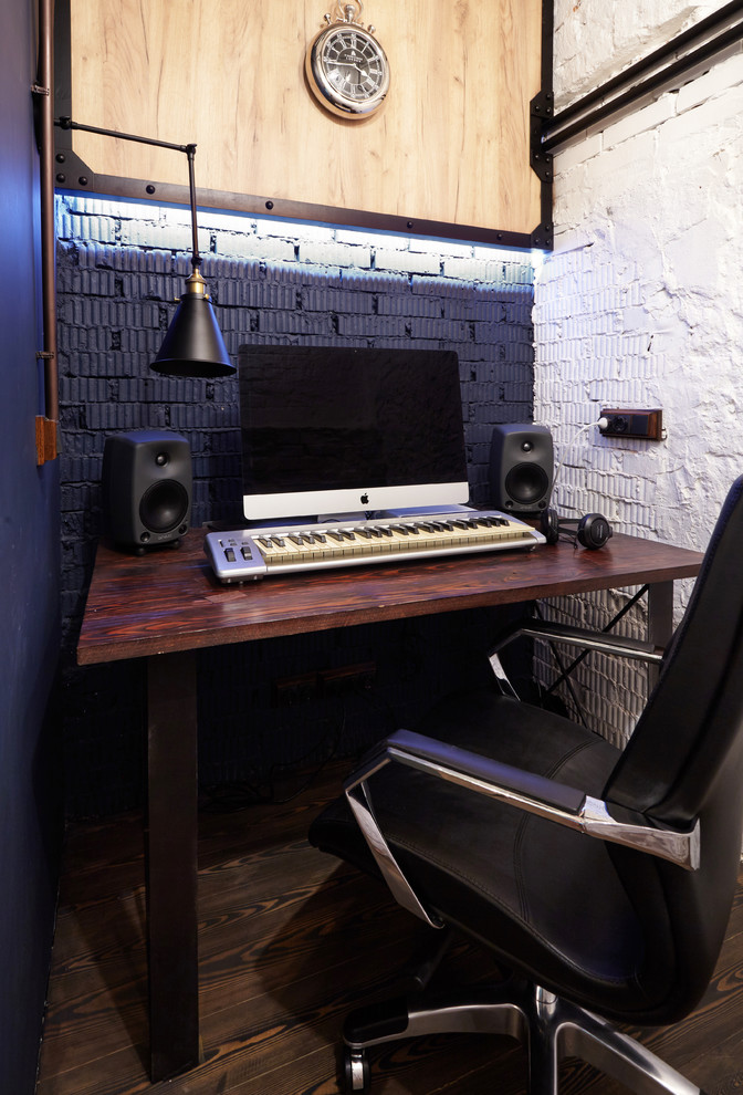This is an example of a small industrial study room in Moscow with blue walls, dark hardwood floors, a freestanding desk and brown floor.