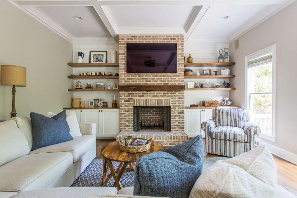 Inspiration for a country open concept family room in Atlanta with beige walls, medium hardwood floors, a brick fireplace surround, a standard fireplace, a wall-mounted tv, brown floor, coffered and planked wall panelling.