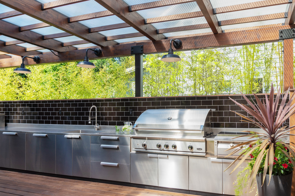 Outdoor kitchen deck - mid-sized contemporary backyard ground level outdoor kitchen deck idea in Seattle with a pergola
