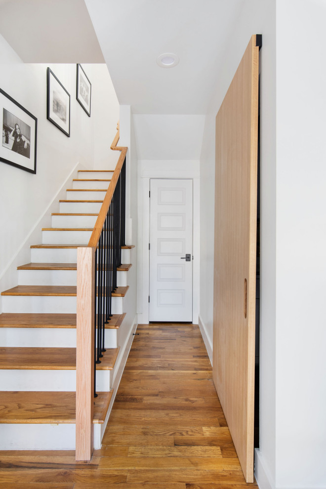 Example of a small transitional medium tone wood floor and brown floor hallway design in Austin with white walls