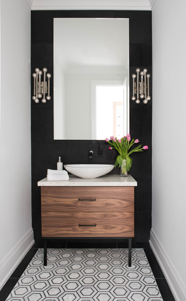 Inspiration for a contemporary powder room in Toronto with flat-panel cabinets, medium wood cabinets, a vessel sink, marble benchtops, black walls and beige benchtops.