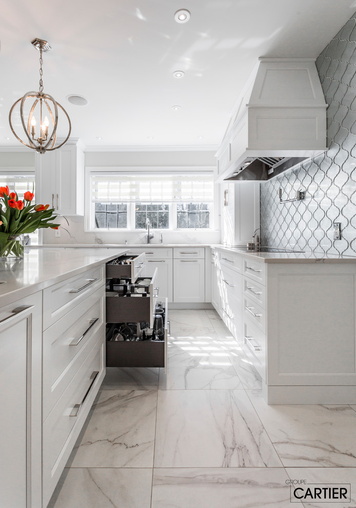 Example of a huge transitional l-shaped marble floor eat-in kitchen design in Montreal with an undermount sink, shaker cabinets, white cabinets, quartzite countertops, gray backsplash, glass tile backsplash, paneled appliances and an island