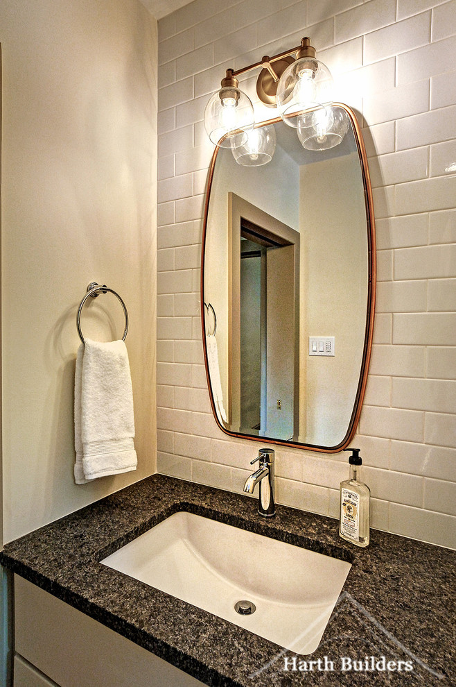 This is an example of a small transitional master bathroom in Philadelphia with raised-panel cabinets, beige cabinets, an alcove shower, a two-piece toilet, white tile, subway tile, beige walls, mosaic tile floors, an undermount sink, granite benchtops, white floor, a hinged shower door and black benchtops.