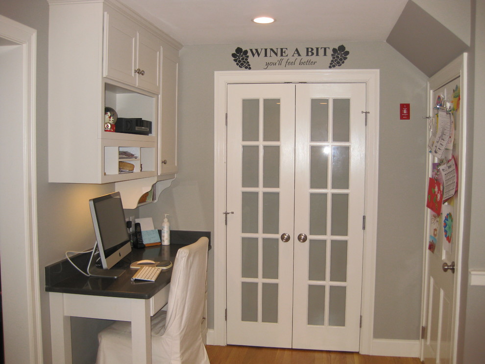 Inspiration for a transitional l-shaped medium tone wood floor eat-in kitchen remodel in Boston with an undermount sink, white cabinets, quartz countertops, stainless steel appliances, an island, shaker cabinets, green backsplash, subway tile backsplash and black countertops