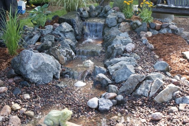 Inspiration for a mid-sized traditional backyard full sun formal garden for spring in Chicago with natural stone pavers and with pond.