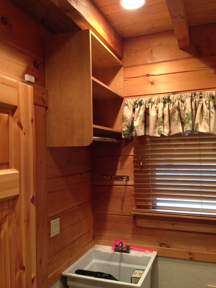 Mid-sized mountain style single-wall carpeted home design photo with open cabinets, medium tone wood cabinets, brown walls and a side-by-side washer/dryer