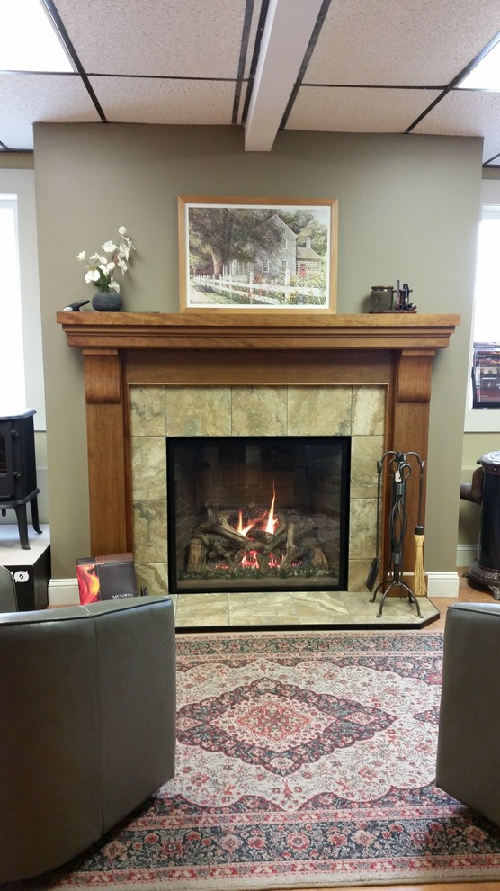 This is an example of a large traditional living room in Portland Maine with green walls, a standard fireplace and a tile fireplace surround.