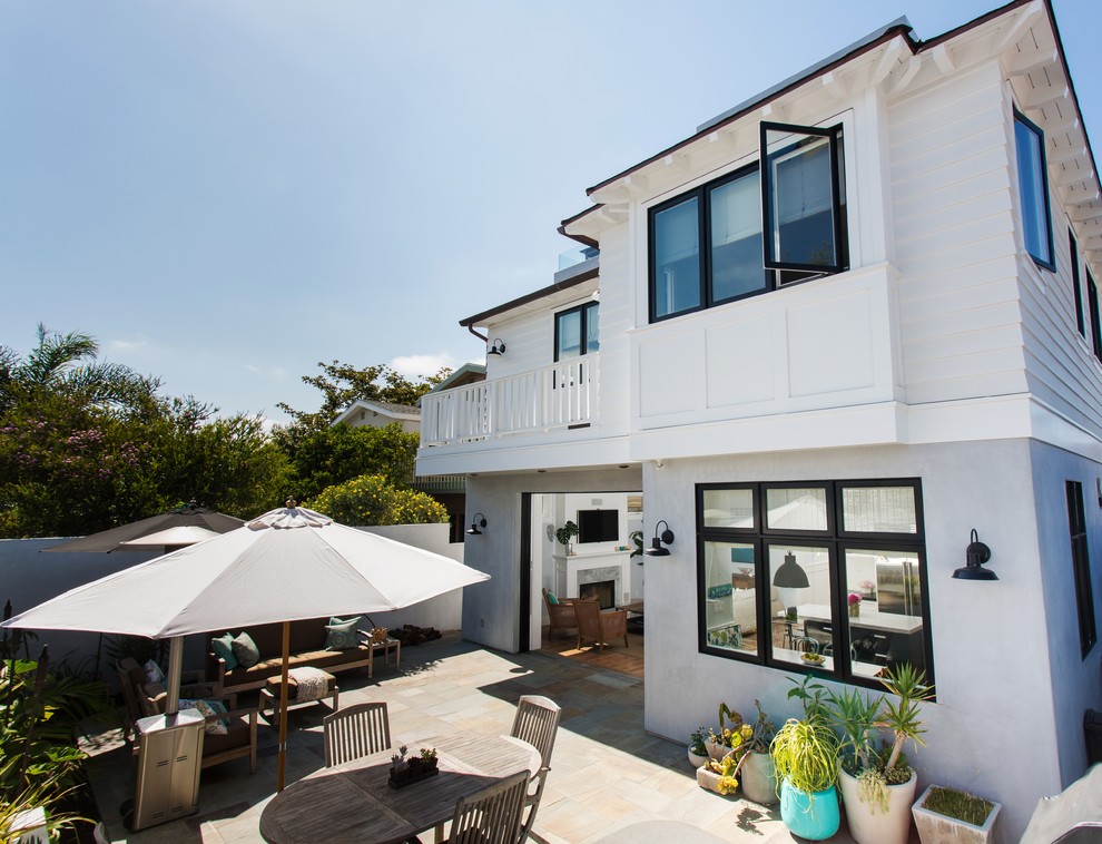 This is an example of a large beach style two-storey white exterior in Los Angeles with mixed siding and a hip roof.