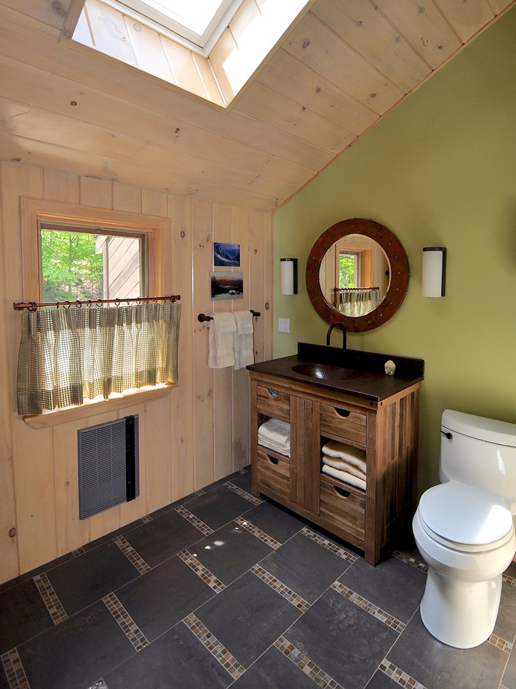 This is an example of a mid-sized arts and crafts master bathroom in Manchester with an integrated sink, furniture-like cabinets, medium wood cabinets, a one-piece toilet, brown tile, mosaic tile, green walls, porcelain floors and copper benchtops.