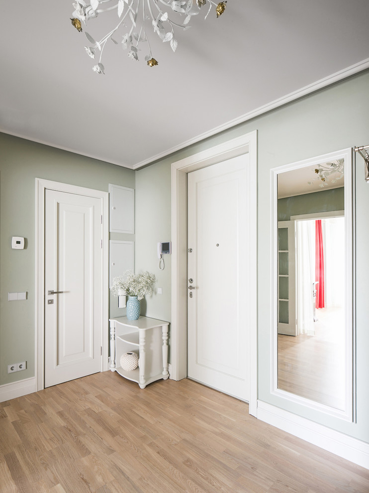 This is an example of a contemporary front door in Saint Petersburg with grey walls, light hardwood floors, a single front door and a white front door.