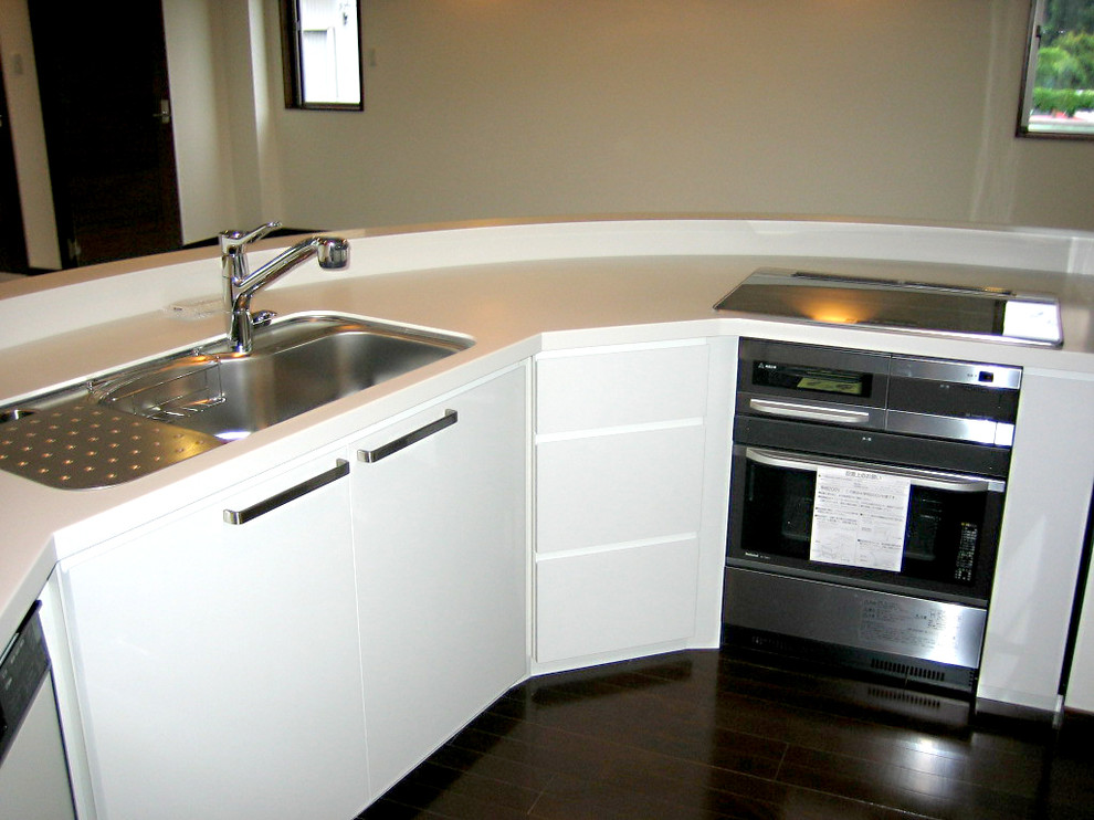 Expansive industrial kitchen in Other with black splashback and white benchtop.