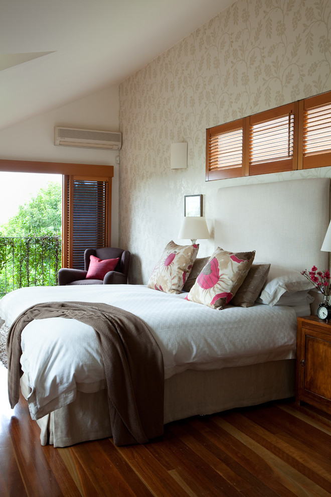 This is an example of a large beach style master bedroom in Brisbane with white walls and medium hardwood floors.