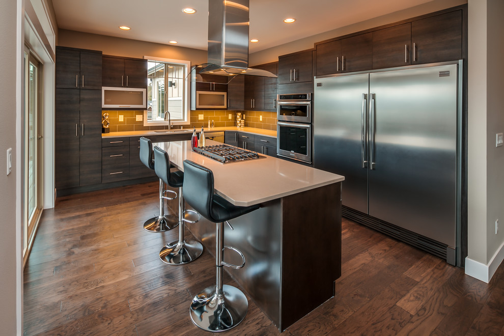 Photo of a large transitional kitchen in Seattle with an undermount sink, flat-panel cabinets, quartzite benchtops, grey splashback, ceramic splashback, stainless steel appliances, dark hardwood floors and with island.