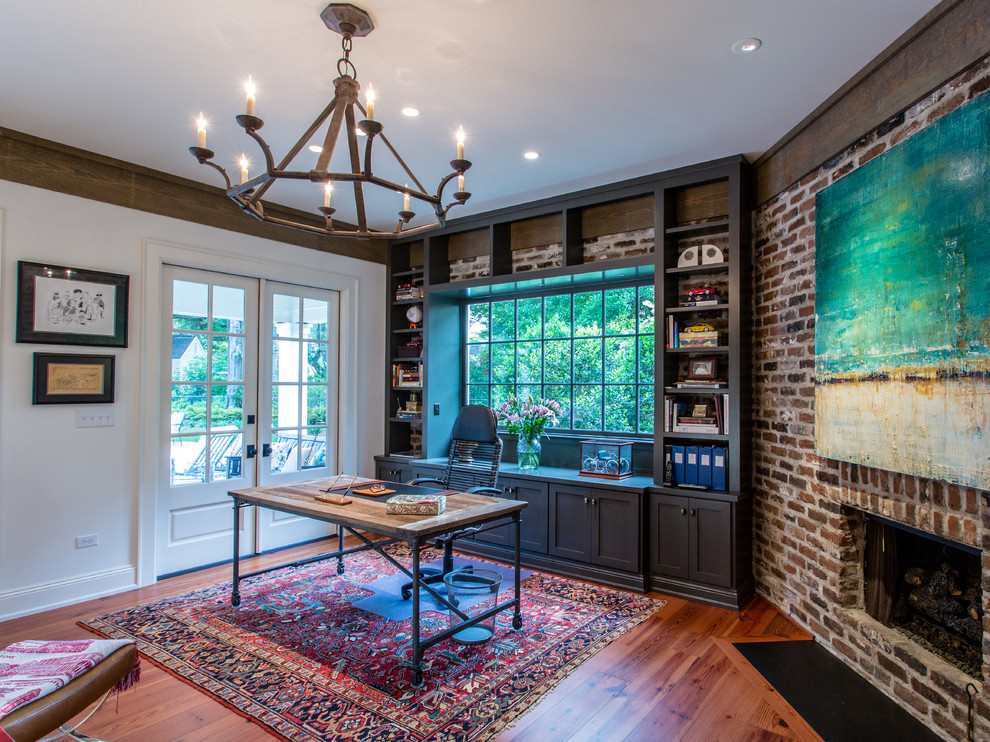 Mid-sized contemporary home office in Other with medium hardwood floors, a corner fireplace, a brick fireplace surround and a freestanding desk.