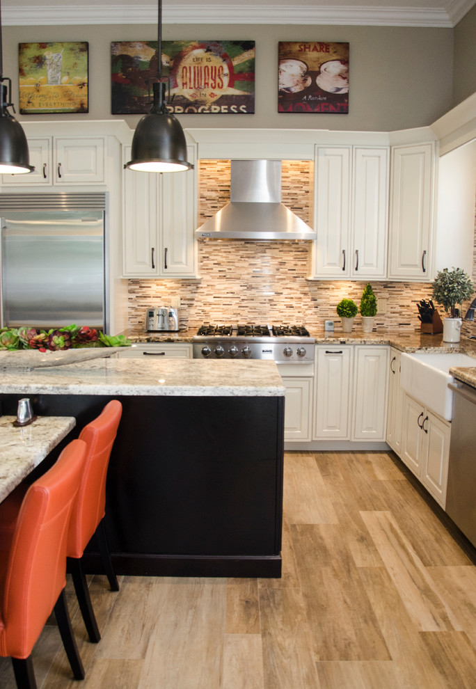 Large transitional l-shaped porcelain tile open concept kitchen photo in Miami with a farmhouse sink, raised-panel cabinets, white cabinets, granite countertops, multicolored backsplash, mosaic tile backsplash, stainless steel appliances and an island