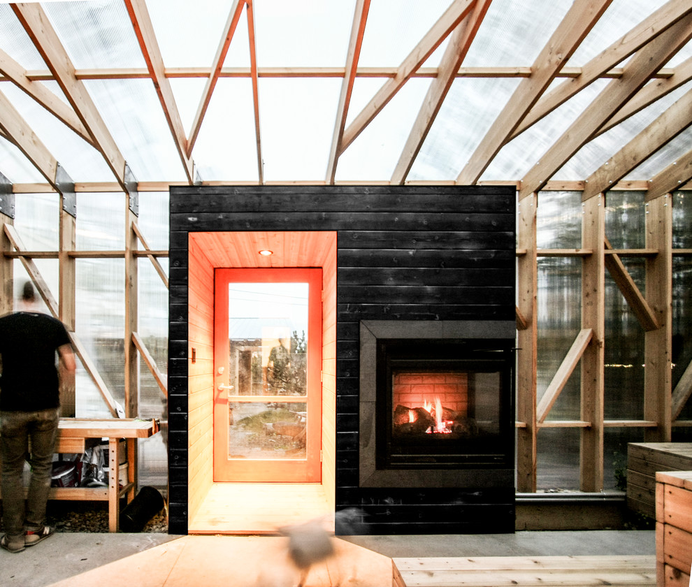 Photo of a mid-sized scandinavian backyard verandah in Calgary with a fire feature and a roof extension.