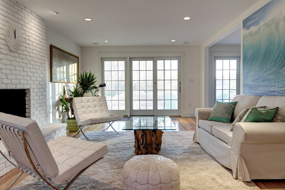 This is an example of a transitional living room in Boston with white walls, medium hardwood floors, a standard fireplace and a brick fireplace surround.
