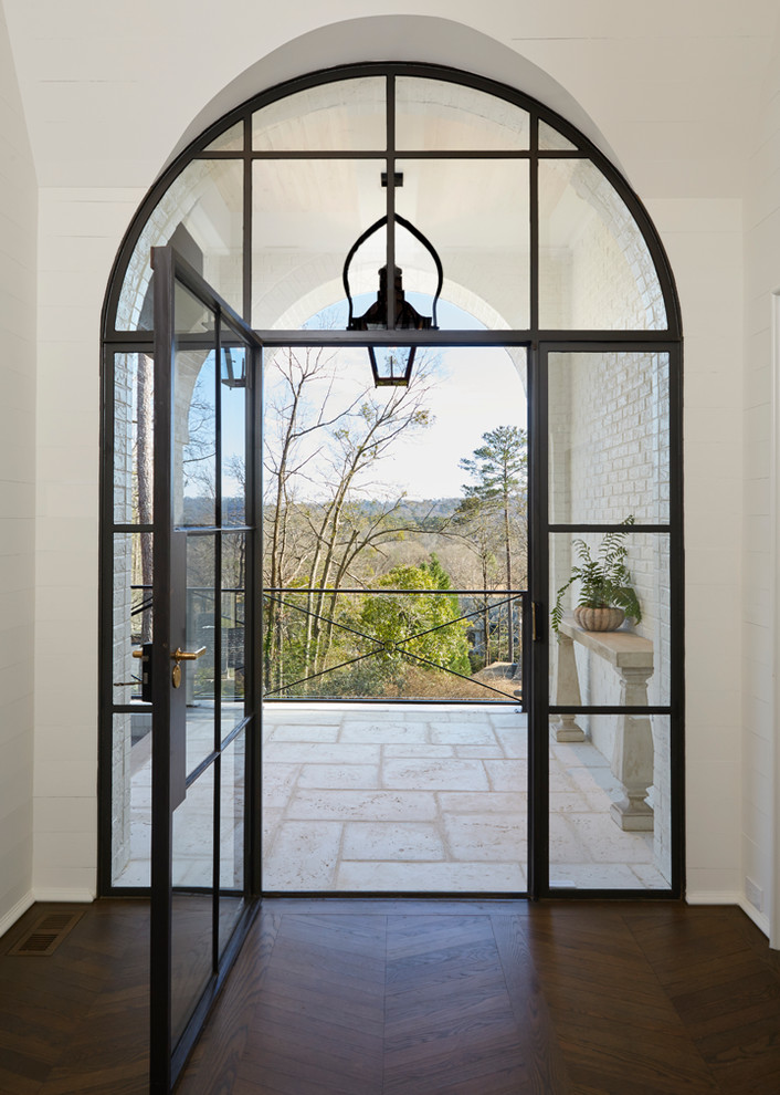 This is an example of a mid-sized mediterranean foyer in Birmingham with white walls, dark hardwood floors and a single front door.