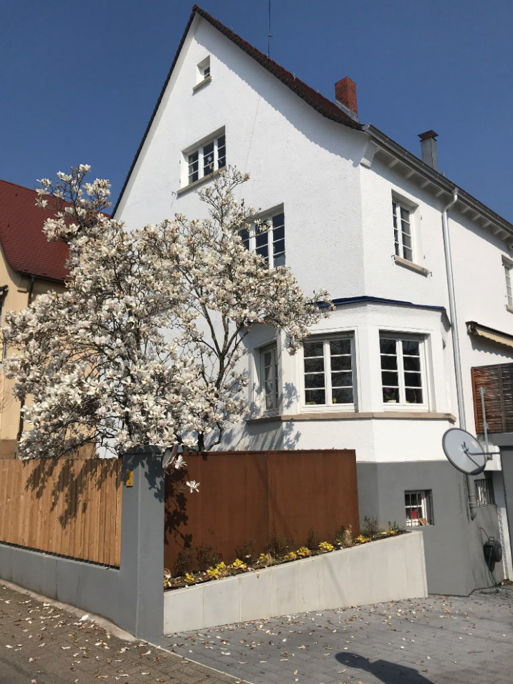 Halbschattiger Landhaus Vorgarten im Frühling mit Auffahrt, Sichtschutz, Betonboden und Metallzaun in Stuttgart
