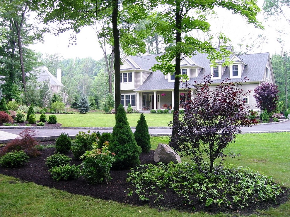 Large traditional partial sun garden in New York with a container garden and natural stone pavers for spring.