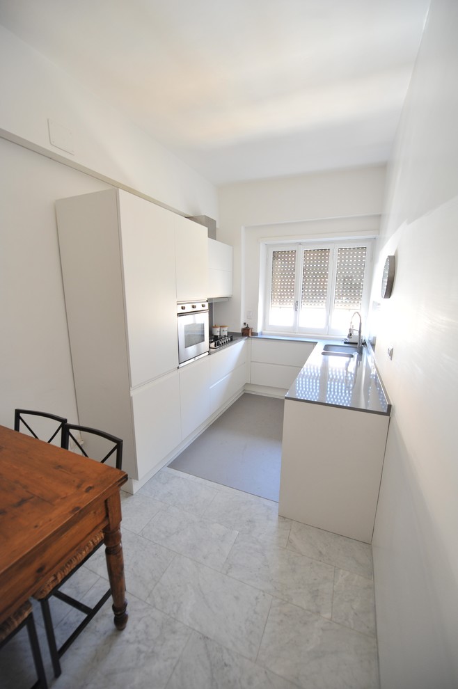 Photo of a small contemporary l-shaped separate kitchen in Rome with a double-bowl sink, flat-panel cabinets, white cabinets, quartzite benchtops, marble floors, no island and white floor.