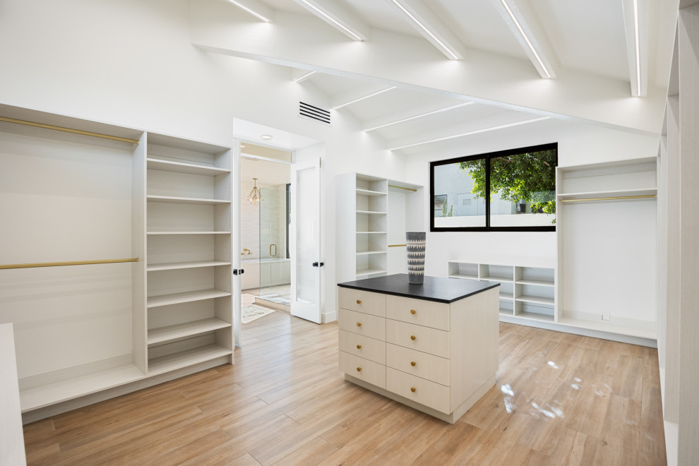 Large transitional gender-neutral porcelain tile, beige floor and exposed beam walk-in closet photo with flat-panel cabinets and light wood cabinets