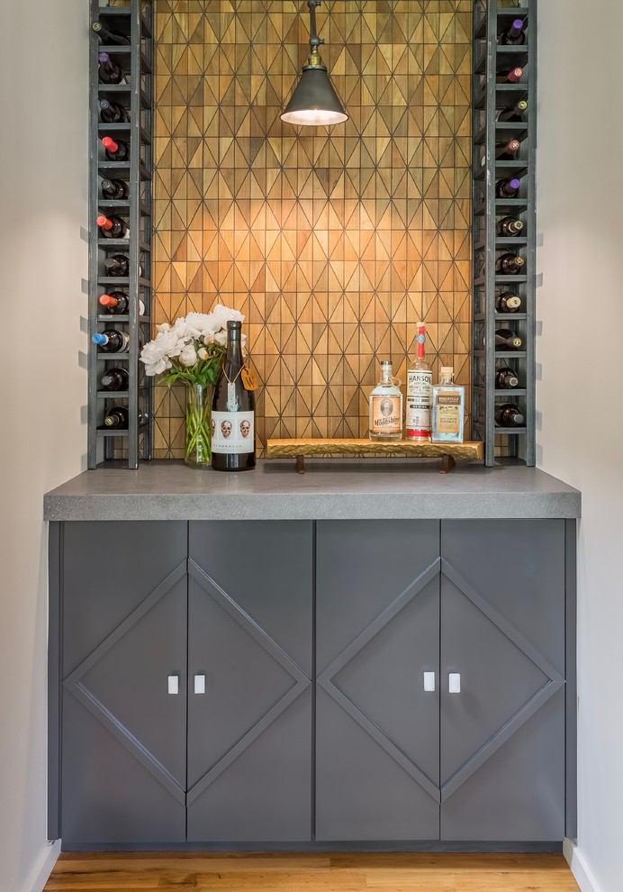 Photo of a small transitional single-wall home bar in Seattle with granite benchtops, brown splashback, timber splashback, medium hardwood floors, no sink, grey cabinets and brown floor.