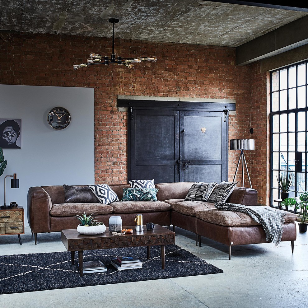 Industrial living room in Other with concrete floors.