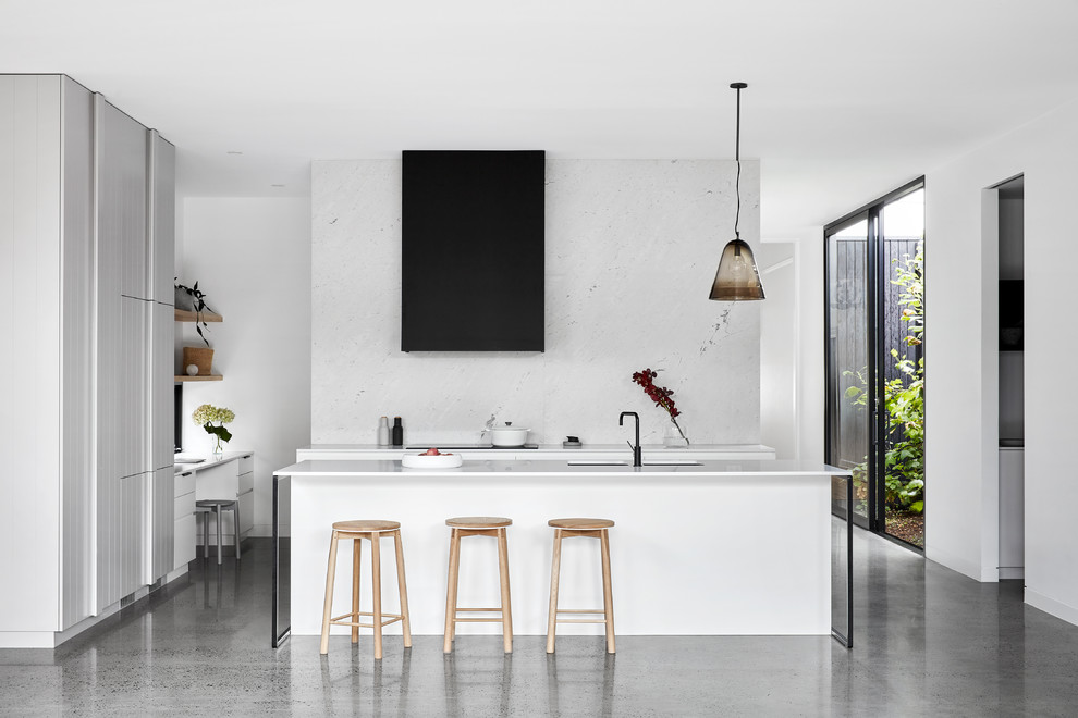 Design ideas for a contemporary u-shaped kitchen in Melbourne with with island, white cabinets, white splashback, white appliances, grey floor, white benchtop and flat-panel cabinets.