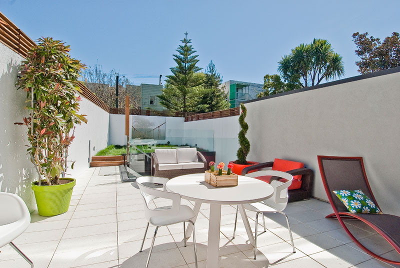 Photo of a mid-sized contemporary courtyard patio in San Francisco with a container garden, tile and no cover.